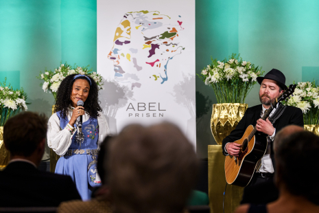 Haddy Njie synger under Abelprisseremonien. Gitarist, Ørnulv M. Snortheim. (Foto: Naina Helén Jåma / Abelprisen)